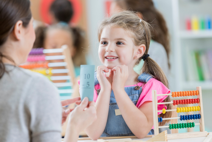 Teacher working one-to-one with a young girl on a dyscalculia and numeracy learning activity