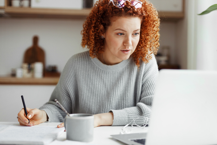 Woman working on a laptop while completing an online dyslexia and dyscalculia teacher training course